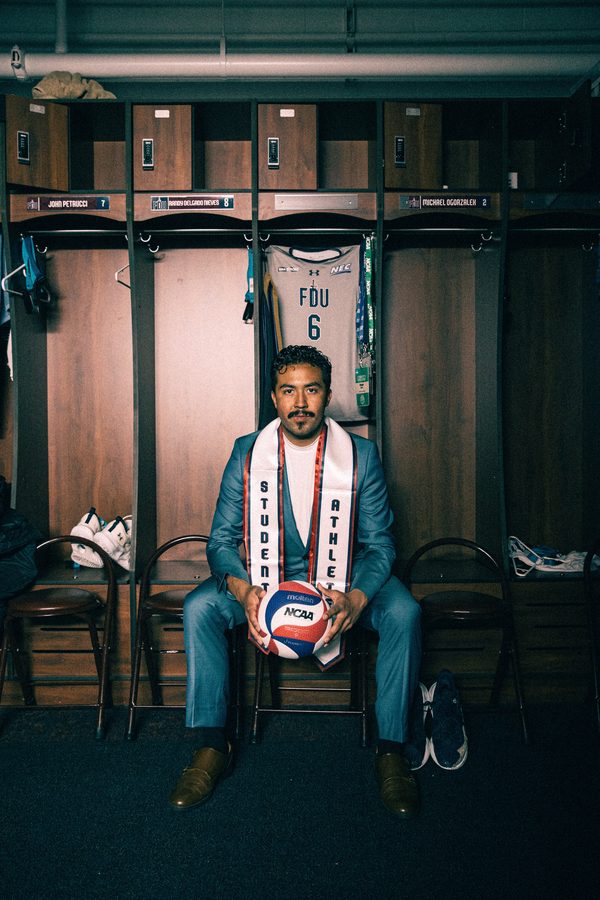 Senior athlete in a stole seated in a locker room holding a volleyball